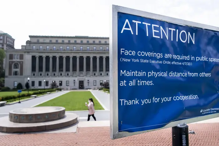 A sign asking people to wear masks and socially distance on the campus of Columbia University in New York, New York, USA, 23 July 2020. Schools and colleges around the country are trying to navigate how students can return to in-person classes in the fall, as the coronavirus pandemic continues to spread in the United States.